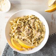 bowl of salmon pesto pasta on blue napkin