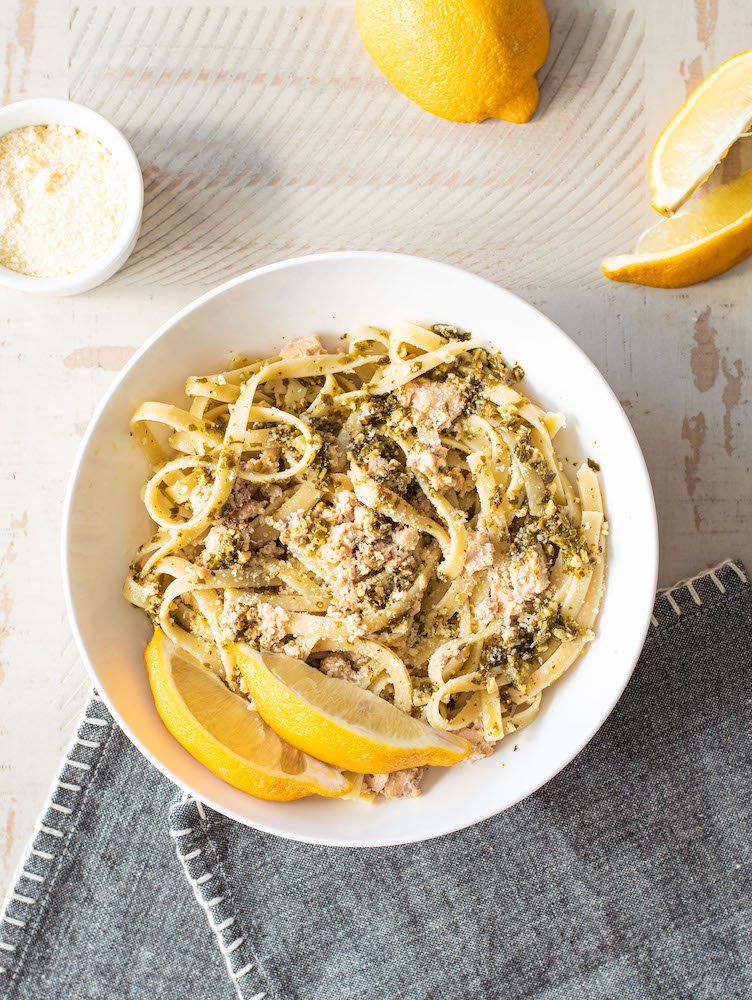 bowl of salmon pesto pasta on blue napkin