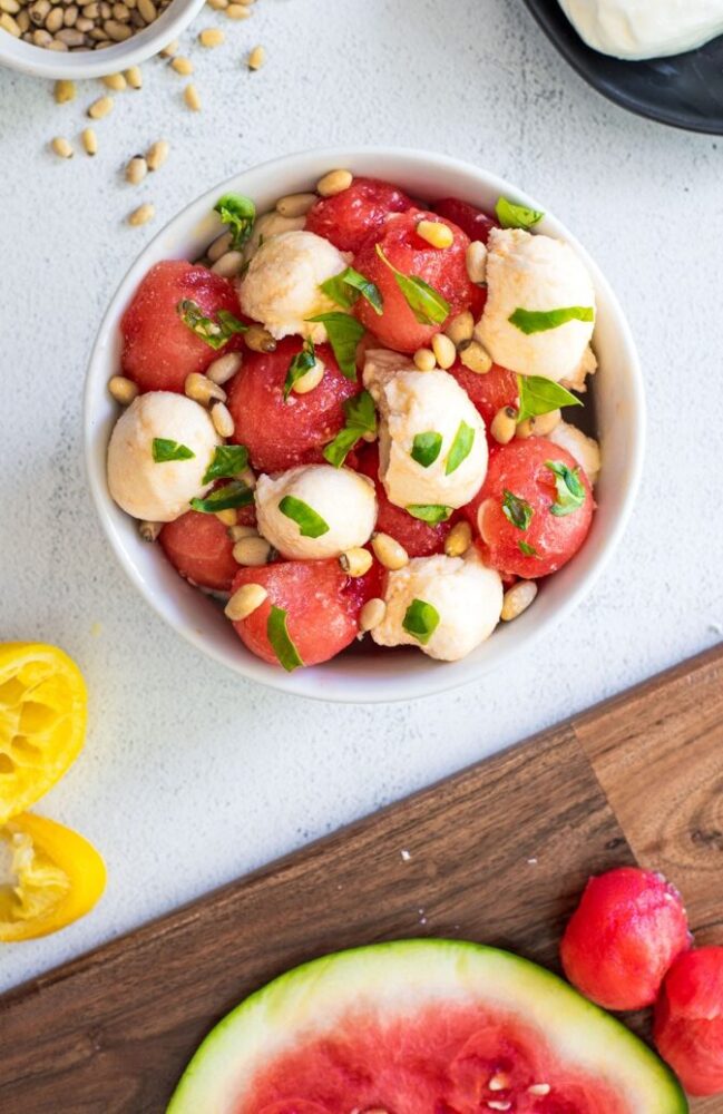 watermelon and mozzarella balls topped with pine nuts and basil