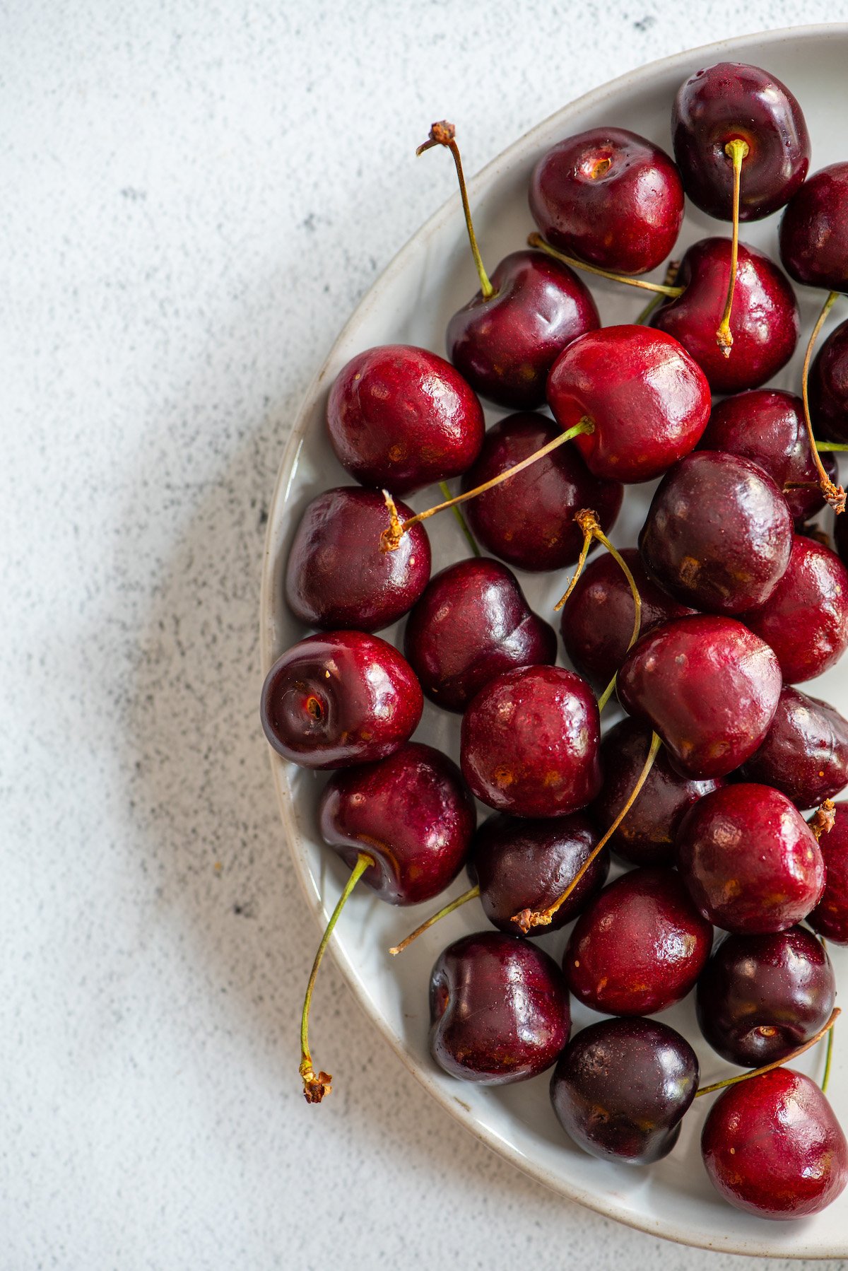 plate of cherries on white background