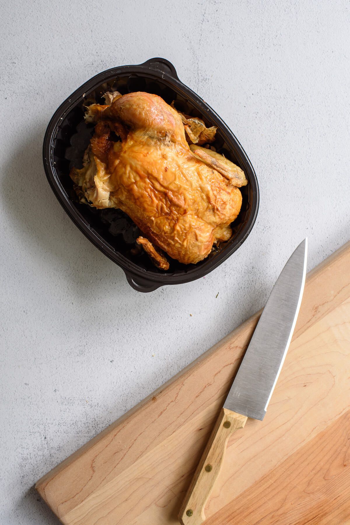 rotisserie chicken next to cutting board with knife