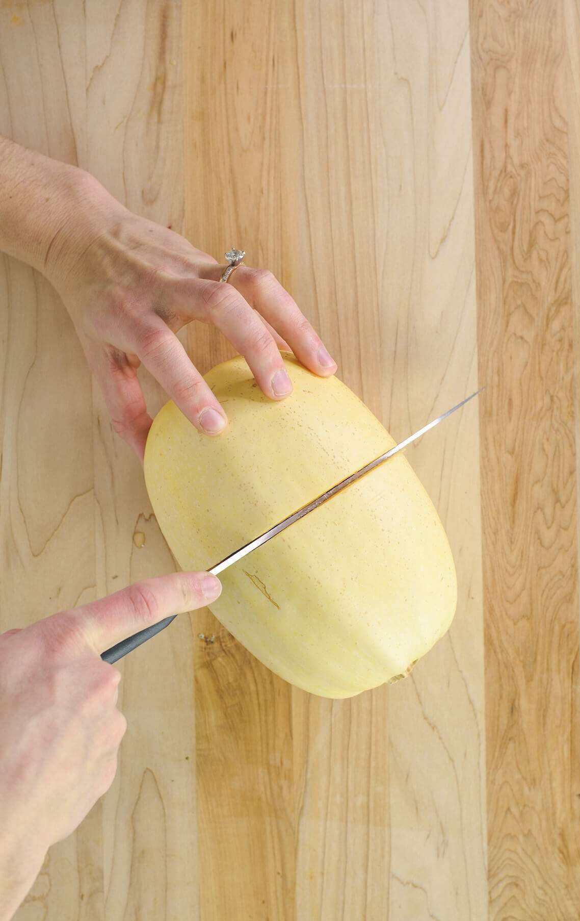 hands cutting spaghetti squash in half