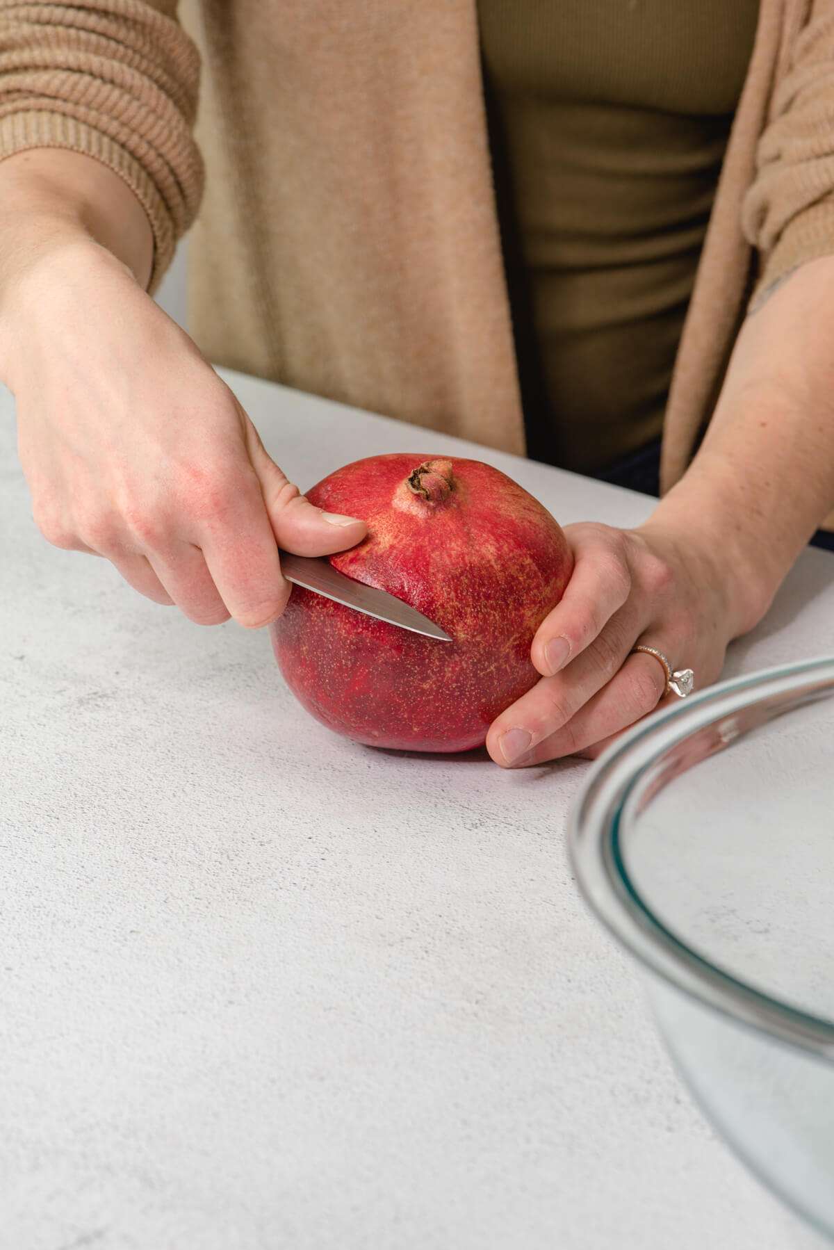 hands cutting pomegranate during pomegranate season