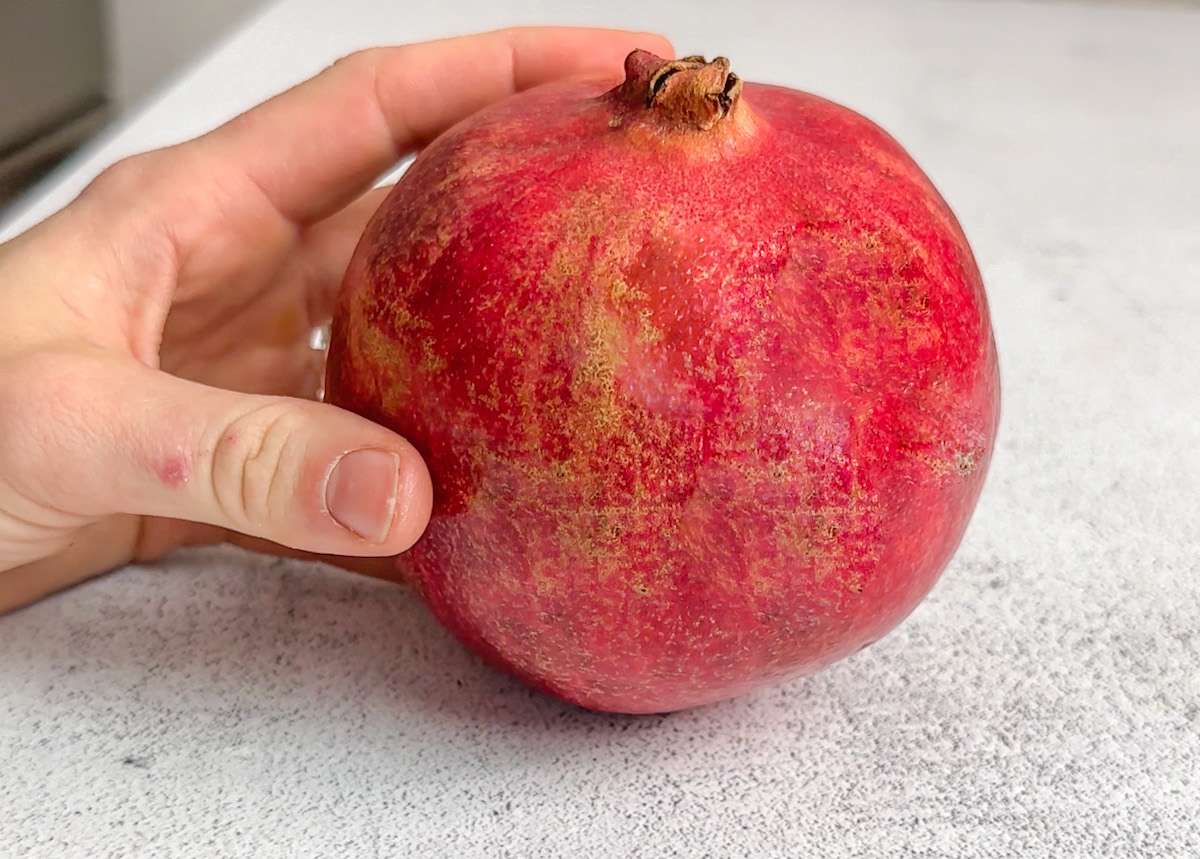 hand holding pomegranate