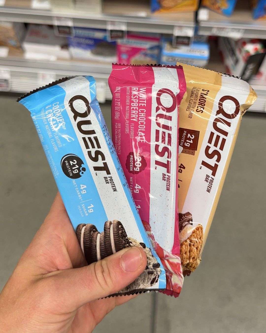 hand holding three flavors of high fiber quest bars