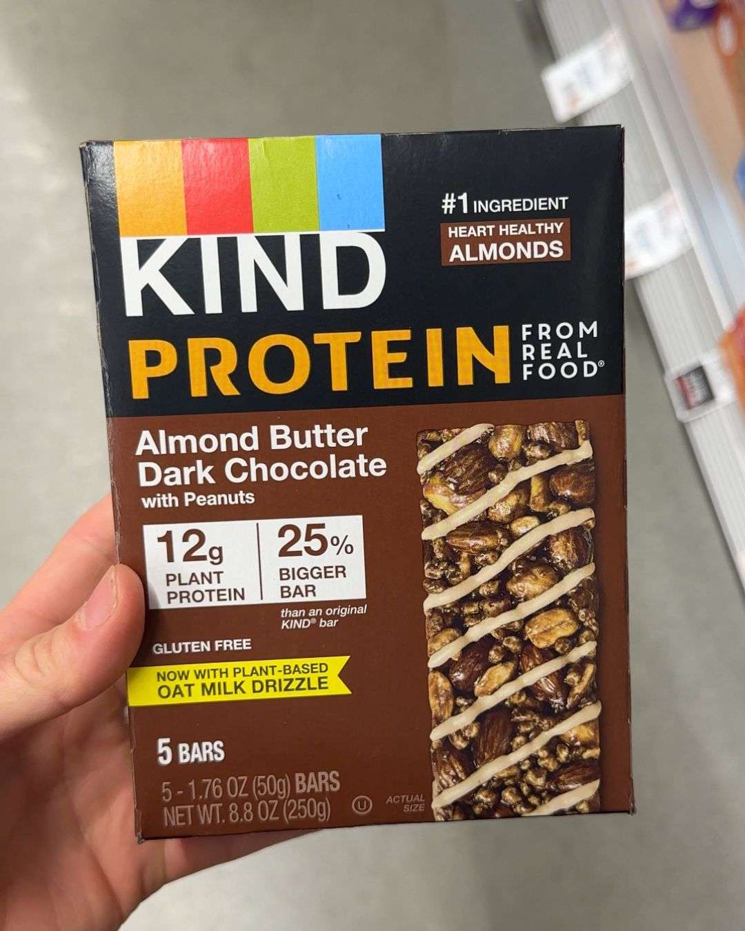 hand holding box of KIND protein max bars