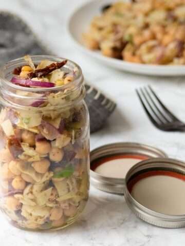 mason jar salad with chickpeas, artichokes, and vegetables